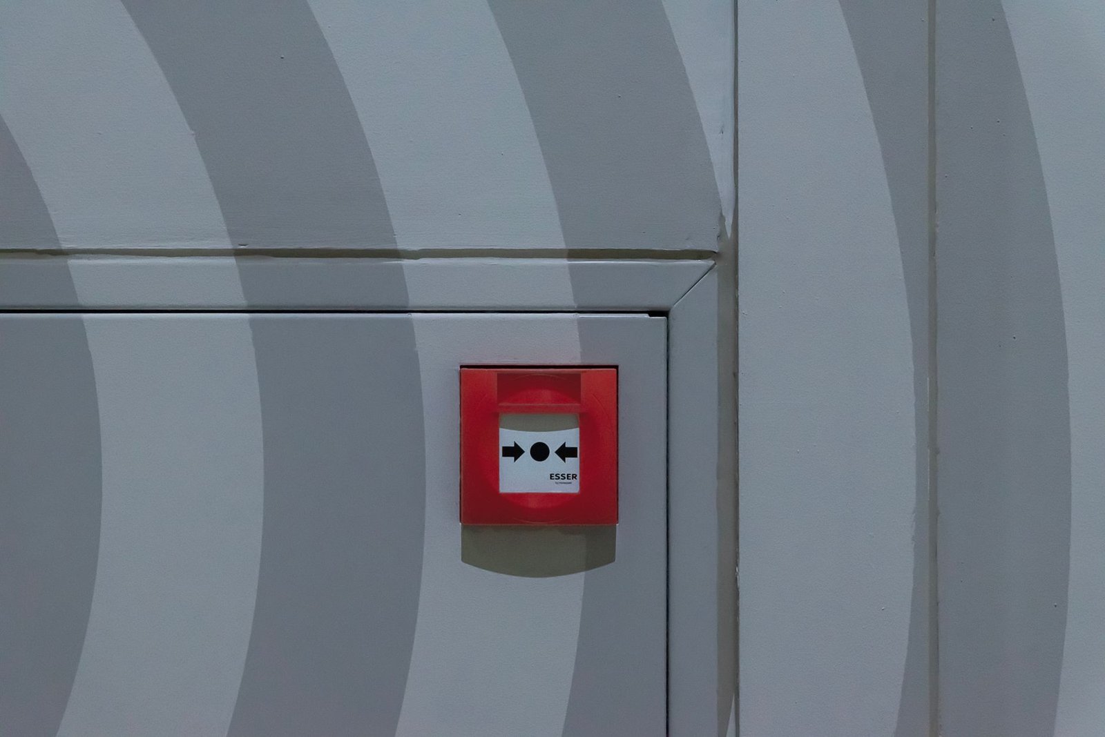 Understanding the PAYE System Certification - Red emergency button on a grey patterned wall, emphasizing safety measures.