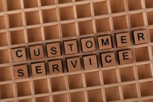 Caring for your Customers’ Needs Certification - Wooden blocks forming the phrase 'Customer Service' placed inside a wooden grid, symbolizing support and assistance.
