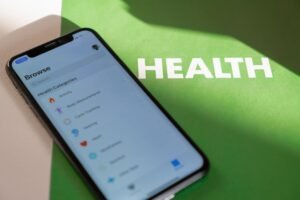 Health and Wellbeing Certification - Close-up of a smartphone displaying a health app on a green surface with 'HEALTH' text.