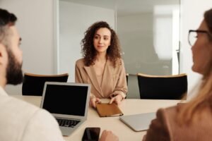 Hiring Employees Certification - A woman in a business suit participates in a job interview, showcasing professionalism and modern office environment.