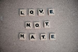 Tackling Hate Crime Certification - Scrabble tiles on pavement spelling the inspirational message 'Love Not Hate'.