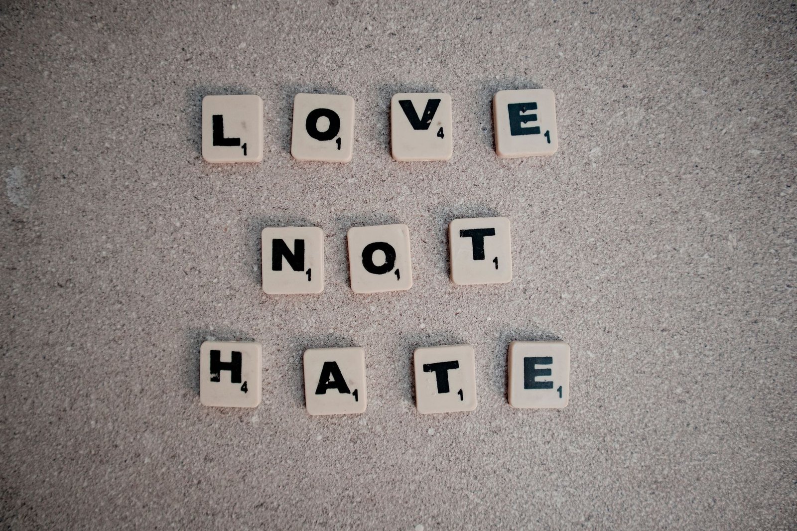 Tackling Hate Crime Certification - Scrabble tiles on pavement spelling the inspirational message 'Love Not Hate'.