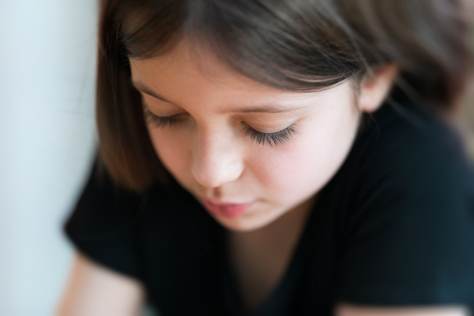 Selective Mutism Awareness Certification - Close-up of a young girl with brunette hair, eyes closed in thought.
