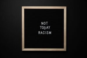 Racism Awareness Certification - Overhead view of phrase Not Today Racism on square framed signboard on black background