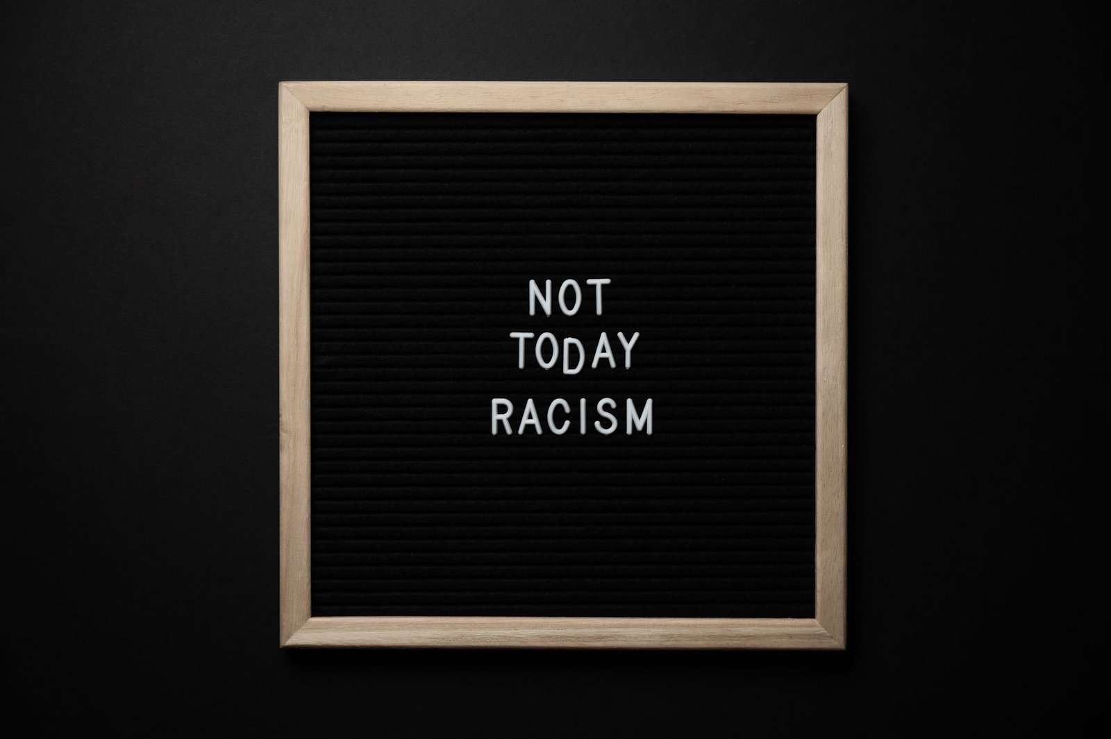 Racism Awareness Certification - Overhead view of phrase Not Today Racism on square framed signboard on black background