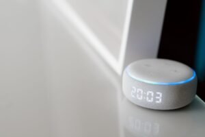 The Internet of Things - Close-up of a smart speaker with a digital clock display on a minimalist surface.
