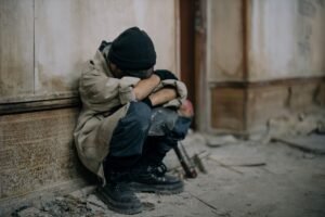 Child Neglect Awareness Certification - A young boy sits alone, appearing sad and forlorn, in an abandoned building setting.