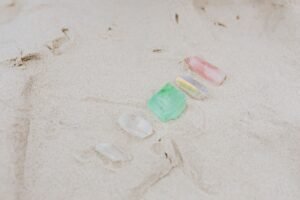 Crystal Healing Certification - A serene arrangement of colorful crystals on sandy beach, showcasing tranquility and natural beauty.