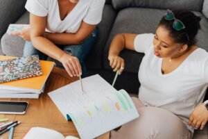 Become an Online Tutor Certification - Two students collaborating at home, discussing notes in a cozy study setting.