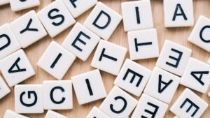 Dyslexia Awareness Certification - Closeup of scattered scrabble tiles against a wooden background, ideal for word games and learning themes.
