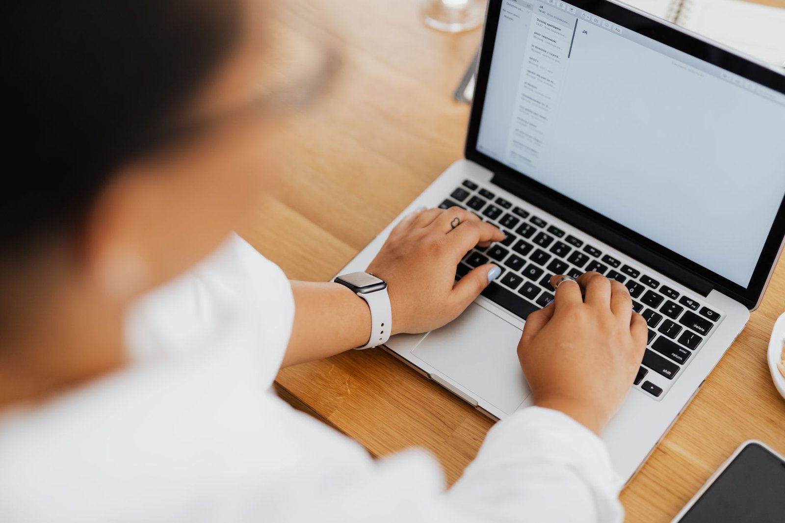 Email Etiquette - High angle shot of a person typing on a laptop, focused on hands and keyboard.