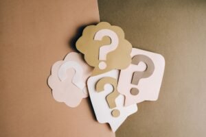 Punctuation Mastery Certification - Question mark cutouts in layered paper craft style on a brown backdrop, conceptual art.