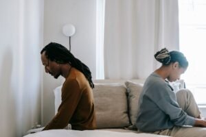 Identifying Causes of Conflict Certification - Side view unhappy sorrowful African American couple sitting on bed back to back after having argument