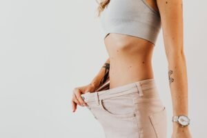 Easy and Achievable Weight Loss Certificate - Close-up of a woman in oversized jeans symbolizing weight loss in a studio setting.