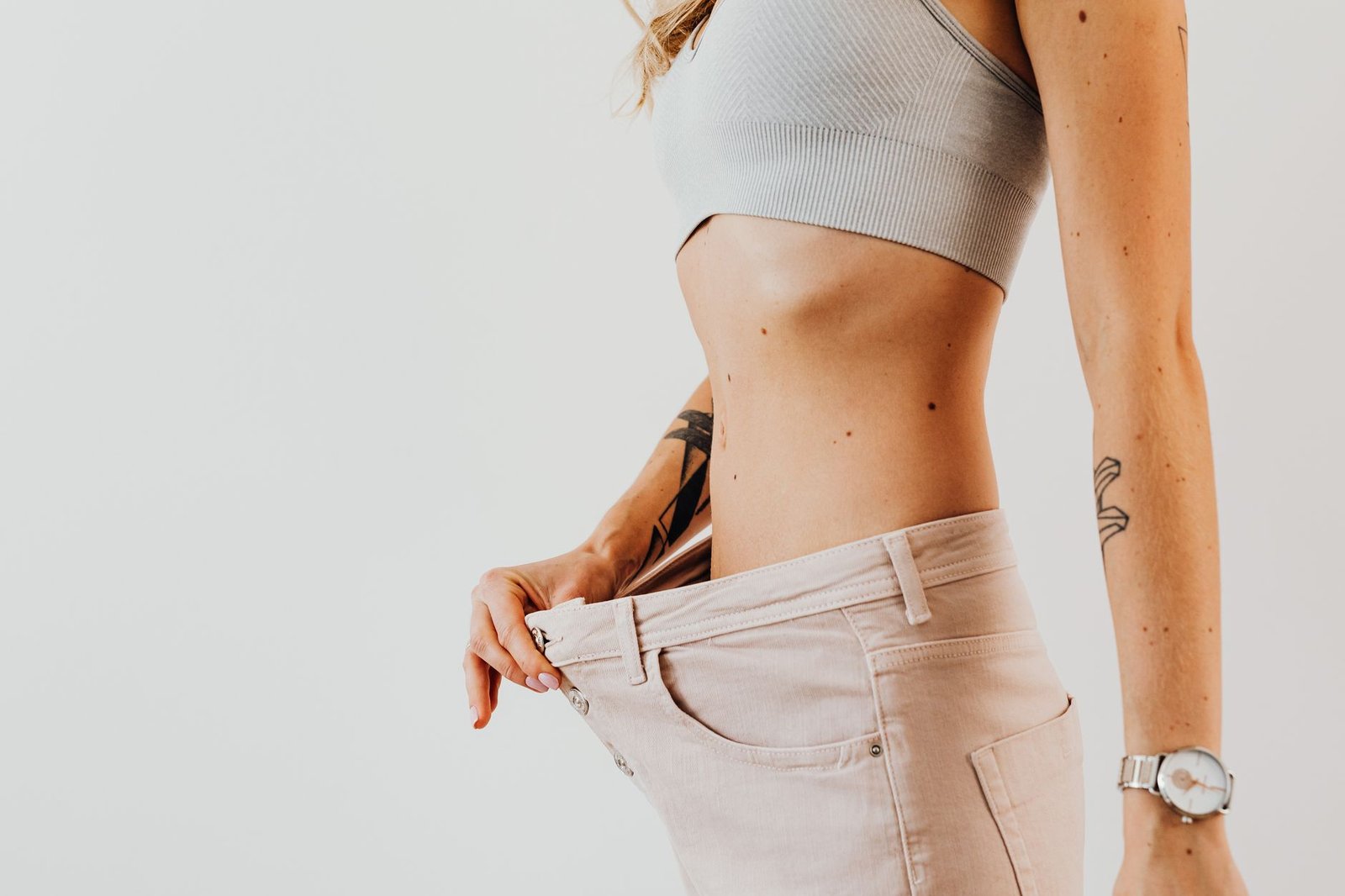 Easy and Achievable Weight Loss Certificate - Close-up of a woman in oversized jeans symbolizing weight loss in a studio setting.