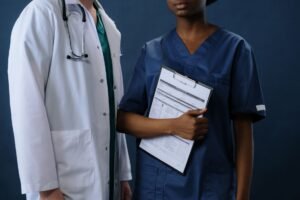 Recruiting Staff in the Healthcare Sector Certification - Two healthcare professionals in scrubs and lab coat with a clipboard, representing teamwork.