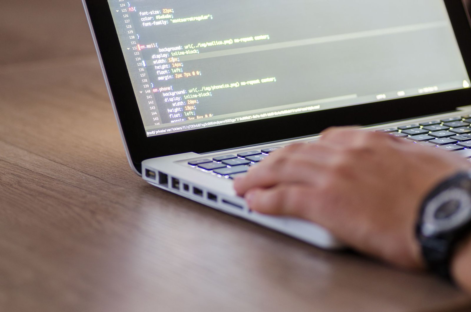 Neuro-Linguistic Programming Certification - Person coding on a laptop with HTML code on screen, showcasing development work.