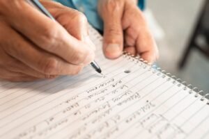 Note Taking Certification - Detailed image of hands writing in a notebook, emphasizing creativity and organization.