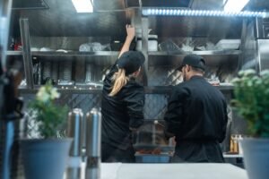 Working in the Service Industry Certification - Two chefs working together in a commercial kitchen, preparing food.