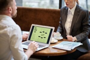 SEO for Business Certification - A man and woman engaged in a business meeting discussing SEO strategy in a cozy cafe setting.
