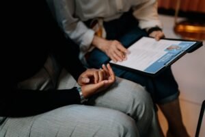 Safer Recruitment Certification - Two professionals reviewing a resume in an office setting, focused on teamwork.