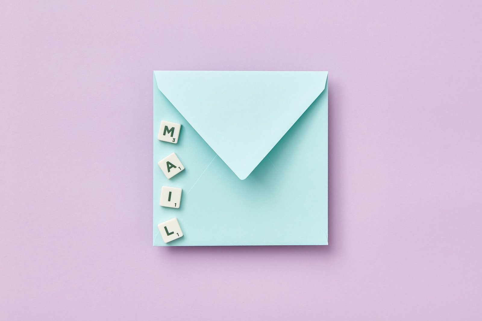 Microsoft Mail Merge Certification - Minimalist flat lay showing a blue envelope and 'MAIL' spelled with Scrabble tiles on a purple background.