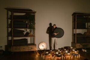 Sound Healing Certification - A man playing Tibetan singing bowls indoors, creating a soothing atmosphere.