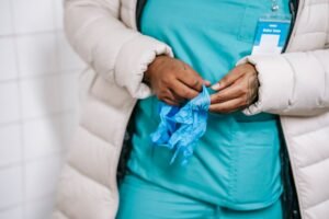 Hand Hygiene in the Care Sector Certification - Crop unrecognizable ethnic female in uniform with latex gloves before work in hospital