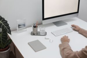 Clear Workspaces - High angle of crop faceless person sitting at table with wireless gadgets and computer