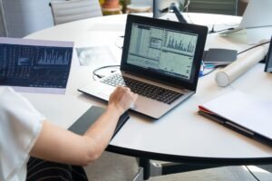 Data Analysis Certification - Business person evaluating financial charts on a laptop in a modern office setting.