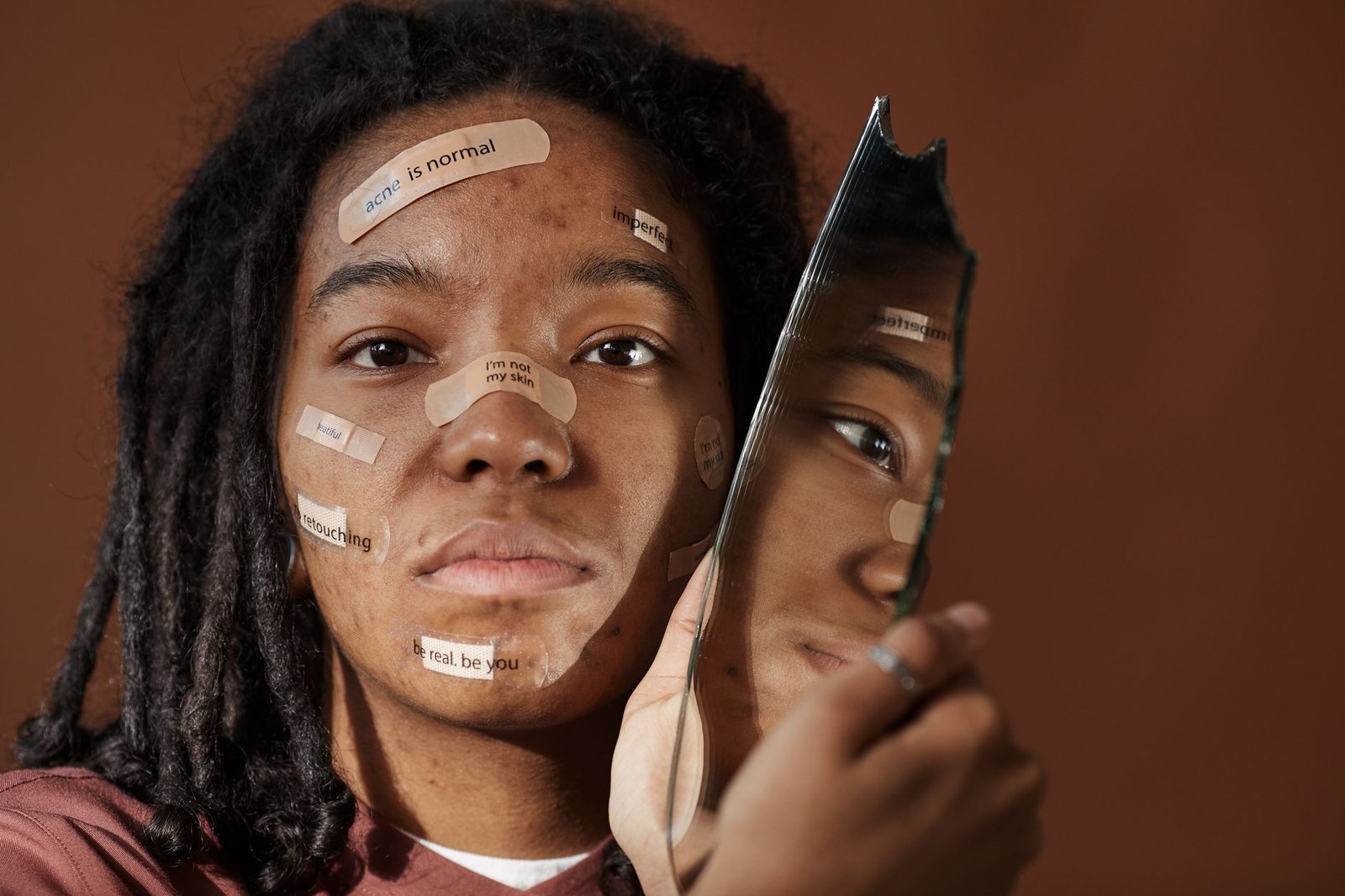Self-harm Awareness Certification - A powerful portrait of a woman embracing imperfections with positive messages on her face, holding a broken mirror.