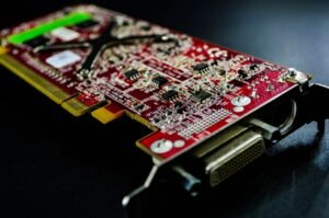 PCI DSS Certification - Detailed close-up of a red circuit board highlighting electronic components and connectors.