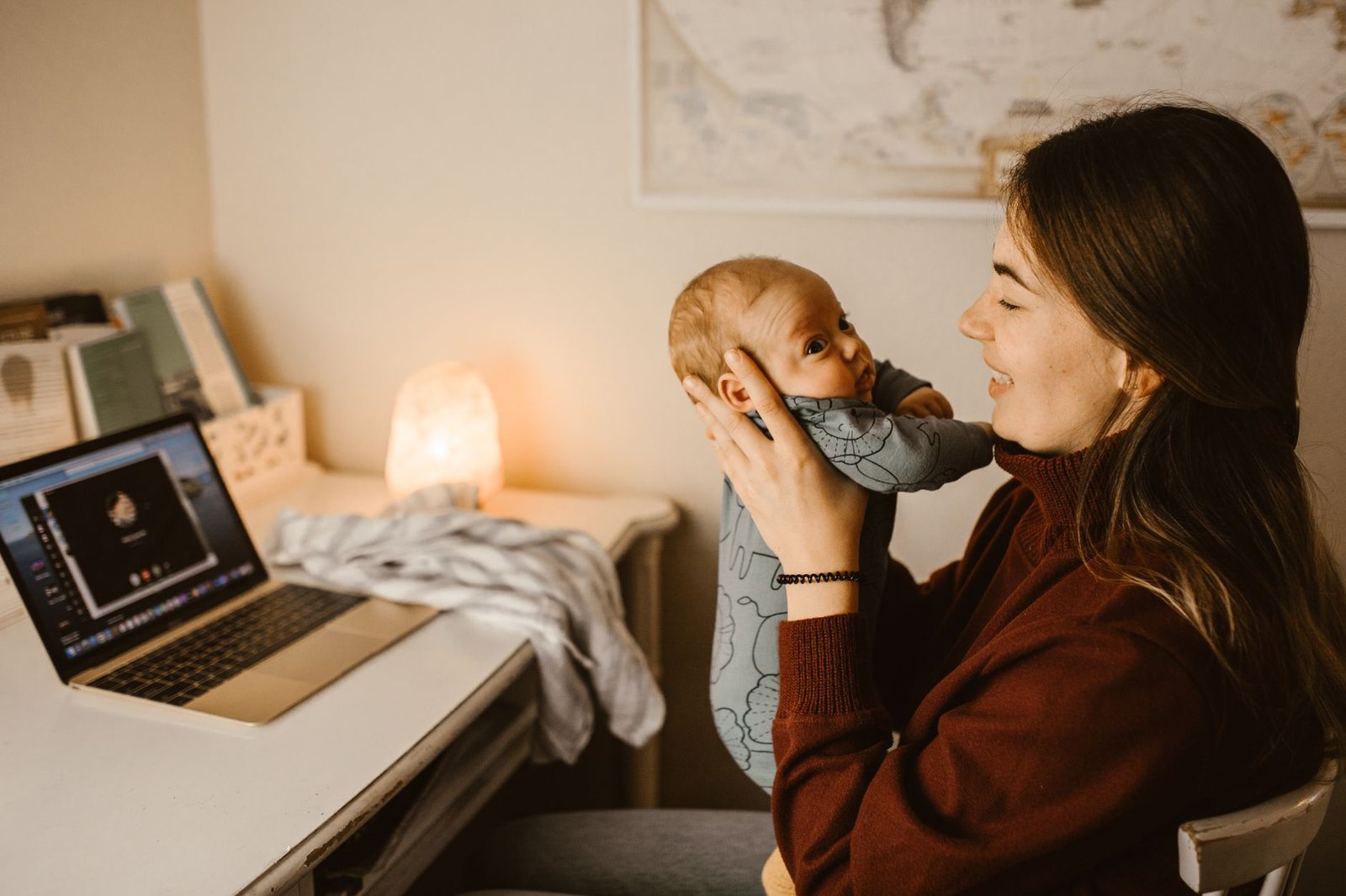Working with Babies Certification - Mother holding baby while video calling from home office. Cozy and heartwarming indoor scene.