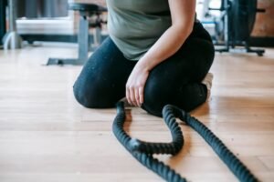 Exercise for Fat Loss Certificate - Crop unrecognizable female in sportswear sitting on floor near sports equipment during weight loss workout