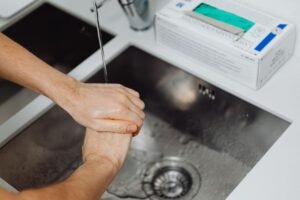 Food Safety Cross Contamination Certification - Detailed view of hands being washed under a tap, emphasizing hygiene and sanitation.