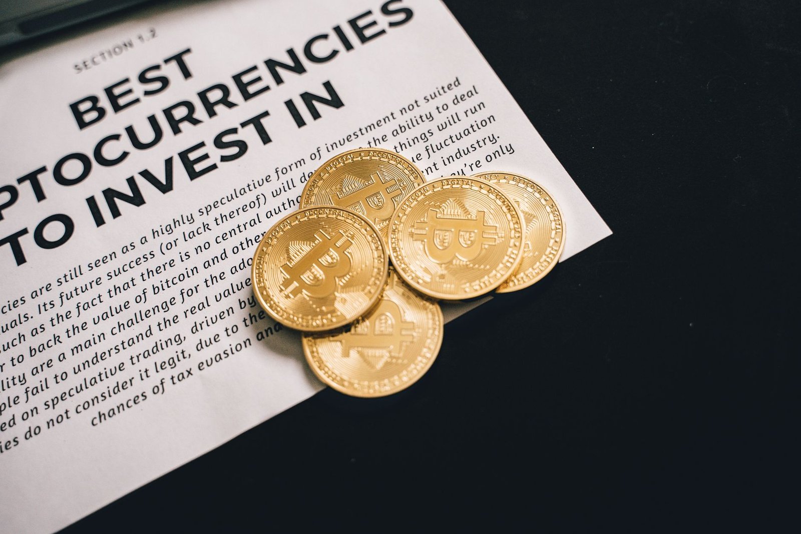Cryptocurrency Certification - Close-up of Bitcoin coins on investment document promoting cryptocurrencies.