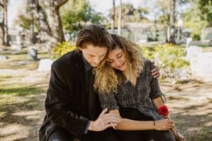 Grief and Bereavement Counselling Certification - A comforting embrace in a serene graveyard captures grief and support.