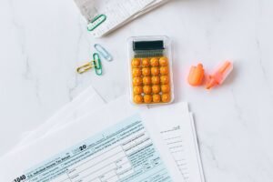 Budgeting Basics Certification - A flat lay image of tax forms, calculator, and office supplies on a desk.