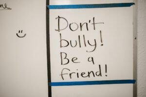 Anti-Bullying and Bullying Prevention Certification - Message against bullying written on a whiteboard, promoting friendship.