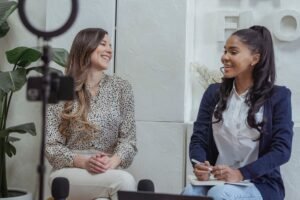 Conducting Interviews Certification - Two women engaged in a lively conversation in a professional interview setting.
