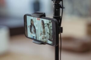 Vlogging Certification - Modern smartphone on tripod recording video of content stylish women having friendly conversation