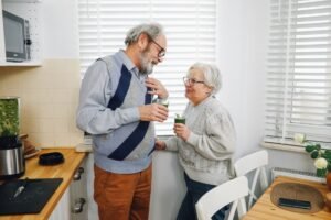 Nutrition for Older Adults Certification - Happy senior couple enjoying refreshing green smoothies together in a cozy kitchen.