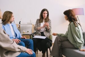 Interpersonal Skills Certification - Female therapist during group session talking to female patients gathering in light cozy office