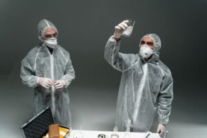 PPE Awareness Certification - Two scientists in PPE conducting an experiment indoors with lab equipment.