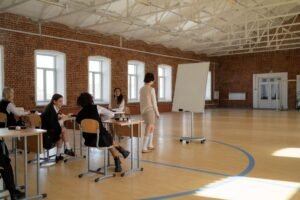 Safeguarding for Students Certification - Students in school uniforms engaged in a lesson with a teacher in a spacious classroom.