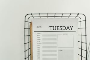 Hourly Planning and Habits Certification - Top view of a minimalist Tuesday planner on a wire basket for organization and scheduling.