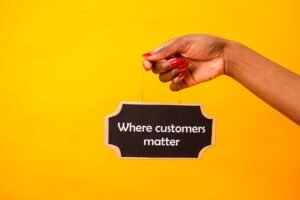 Customer Retention Certification - A close-up of a hand holding a sign stating Where customers matter against a bright yellow background.