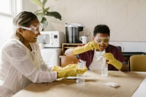 Health and Safety for Homeworkers Certification - A woman and boy conducting a fun science experiment indoors with safety goggles and gloves.