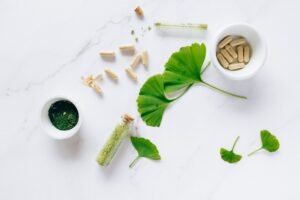Naturopathy Certification - Flat lay of herbal supplements with ginkgo leaves on marble surface, emphasizing natural health remedies.