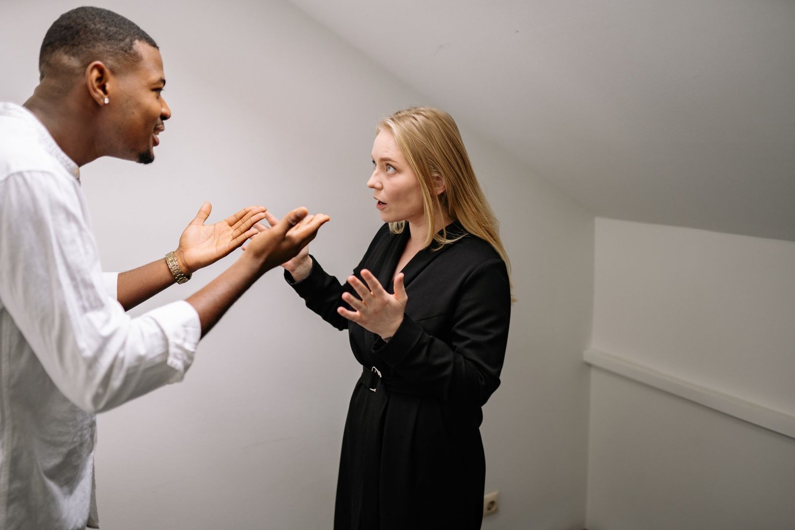 Handling Conflict in High-Value Relationships Certification - A man and woman having a heated discussion in a minimalistic indoor space.